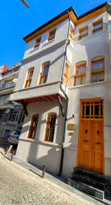 een wit gebouw met een houten deur op een straat bij HanFlats in Istanbul