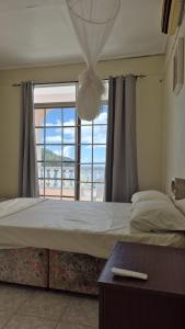Un dormitorio con una cama con una ventana grande. en Ocean Sea view, en Galion 19 fotos más