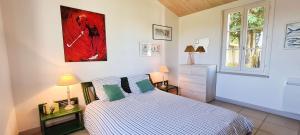 een slaapkamer met een bed en een schilderij aan de muur bij Dans le centre de la Couarde, superbe villa familiale in La Couarde-sur-Mer