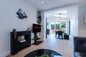 3 Bedroom Free Parking Hale Home في هييل: غرفة معيشة مع موقد وطاولة