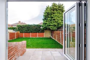 3 Bedroom Free Parking Hale Home في هييل: باب مفتوح إلى الفناء الخلفي مع حديقة