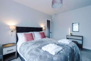 3 Bedroom Free Parking Hale Home في هييل: غرفة نوم بها سرير عليه منشفتان