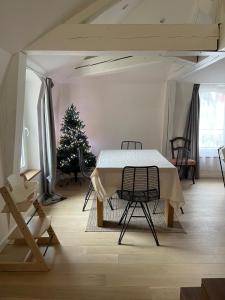 een eetkamer met een tafel en een kerstboom bij Les baleines - hypercentre 2 chambres avec garage et clim - air conditioning in Grenoble