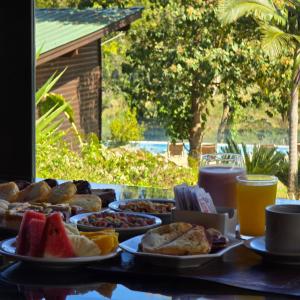 a table topped with plates of breakfast foods and drinks at Tupa Lodge Selva y Rio in Puerto Iguazú