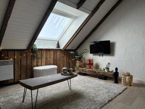 a living room with a skylight and a table at Cocoon Ny - DURBUY in Hotton