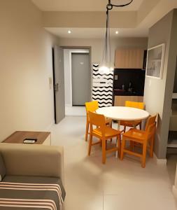 una sala de estar con una mesa, sillas y un sofá en Arte Studios - Flats decorados, wifi, estacionamento, piscina, academia, en Río de Janeiro