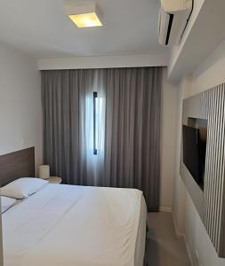 una habitación de hotel con una cama y un televisor en Arte Studios - Flats decorados, wifi, estacionamento, piscina, academia, en Río de Janeiro 88 fotos más