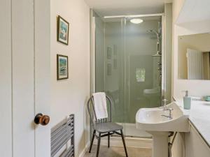 uma casa de banho com um chuveiro, um lavatório e uma cadeira. em 4 Bed in Eskdale SZ158 em Eskdale mais 18 fotografias