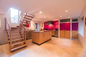 eine Küche mit Wendeltreppe und rosa Wänden in der Unterkunft Sejour prestige a Lannion entre ville et plages in Lannion