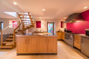 eine Küche mit roten Wänden und einer Wendeltreppe in der Unterkunft Sejour prestige a Lannion entre ville et plages in Lannion