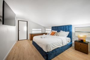 a bedroom with a large bed with a blue headboard at Duplex Suite Old Town in Antibes