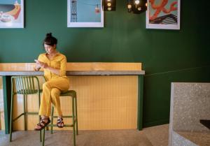 a woman sitting at a bar looking at her cell phone at BYPILLOW Twenty in Barcelona