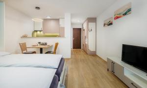a hotel room with a bed and a tv and a table at Figaro in Leukerbad