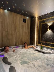 Un hombre y una mujer sentados en un jacuzzi en Moris Beach Hotel, en Gdansk