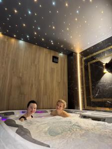 dos niños están sentados en un jacuzzi en Moris Beach Hotel, en Gdansk