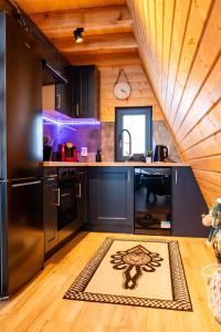 a kitchen with black appliances and a wooden ceiling at The Sun House in Męcina