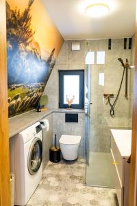 a bathroom with a washing machine and a shower at The Sun House in Męcina