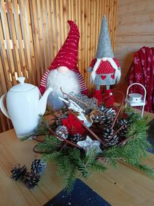 een tafel met een kerststuk met een kerstmuts bij Winnica Zatorska in Olszyny
