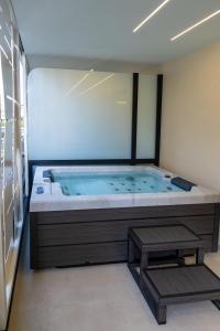 jacuzzi con banco en una habitación en Thea Acropolis Suites & Apartments, en Atenas