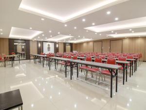 a conference room with tables and red chairs at Sweet Karina Hotel Pasteur in Bandung