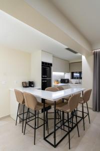 una cocina con una gran mesa blanca y sillas en Thea Acropolis Suites & Apartments, en Atenas