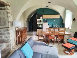 a living room with a couch and a dining room at Logis vouté les hirondelles in Rogna