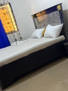 Una cama con dos almohadas encima en una habitación. en Iron guest house, en Yaoundé 15 fotos más