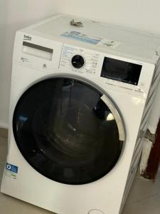 Una lavadora blanca colocada encima de un mostrador en Iron guest house, en Yaoundé