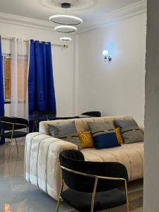sala de estar con sofá y cortinas azules en Iron guest house, en Yaoundé