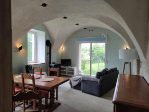 a living room with a table and a couch at Logis vouté les hirondelles in Rogna