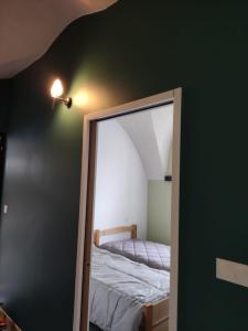 a mirror reflection of a bed in a bedroom at Logis vouté les hirondelles 