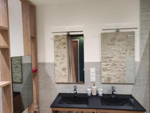 a bathroom with two sinks and a mirror at Logis vouté les hirondelles  +7 photos
