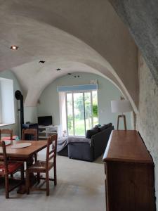 a living room with a table and a couch at Logis vouté les hirondelles 