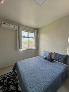 una camera da letto con un letto blu e una finestra di Quarto individual ou casal a Belém