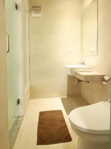 a bathroom with a toilet and a sink and a mirror at Sweet Karina Hotel Pasteur in Bandung