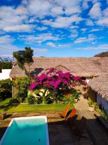 una casa con piscina y flores rosas en Suite com Ar e Wi Fi na Casa Full Hausi Fortim 01, en Fortim
