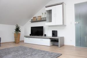 a living room with a flat screen tv on a white wall at Ferienhaus Lirum Larum Löffelstiel in Hemfurth-Edersee