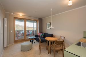 a kitchen and living room with a table and chairs at SEEZIEGE Uckermark - Ferienwohnungen am Carwitzer See in Thomsdorf