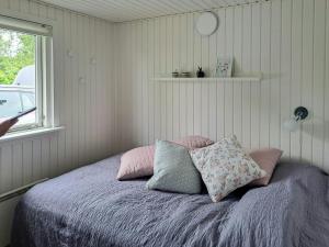 VejlbyskovFamily Holiday Home Close To Beach At Vejlby Fed的一间卧室，配有一张床、枕头和一扇窗户