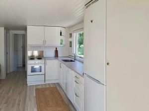 VejlbyskovFamily Holiday Home Close To Beach At Vejlby Fed的白色的厨房配有白色橱柜和炉灶。