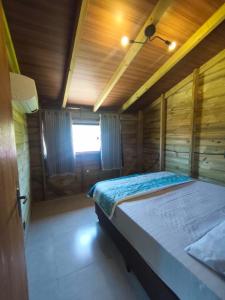 a large bed in a room with a wooden ceiling at Apartamento de 2 Quartos para 4 Pessoas - 5 min da Praia in Garopaba
