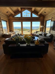 a large living room with a couch and a table at Luxurious Log Cabin At Mostertoppen in Øyer +23 photos