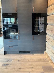 a kitchen with black cabinets and a wooden floor at Luxurious Log Cabin At Mostertoppen in Øyer