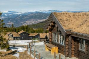 a log cabin with a view of the mountains at Luxurious Log Cabin At Mostertoppen in Øyer