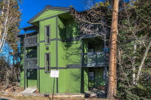 un edificio verde con balconi e un albero di WP Top Floor Getaway a Hideaway Park