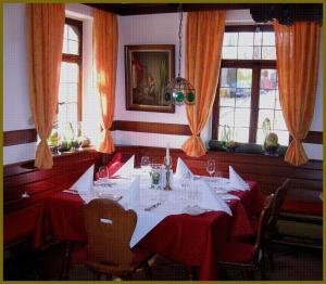 ein Esszimmer mit einem Tisch mit rotem Tischtuch in der Unterkunft Goldner Engel, Restaurant - Hotel - Metzgerei in Laudenbach