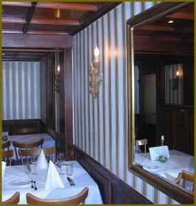 ein Esszimmer mit 2 Tischen und einem Spiegel in der Unterkunft Goldner Engel, Restaurant - Hotel - Metzgerei in Laudenbach