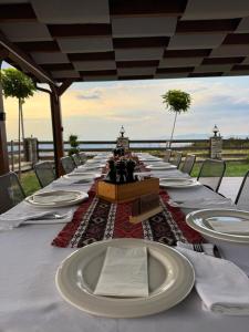 a long table with white plates on top of it at Hotel & Restaurant Mulliri me Erë in Rahovec