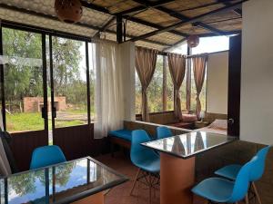 a room with chairs and tables and windows at Villas de Sutamarchan in Sutamarchán