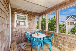 a room with a table and chairs and windows at 8194 - Southern Grace in Waves